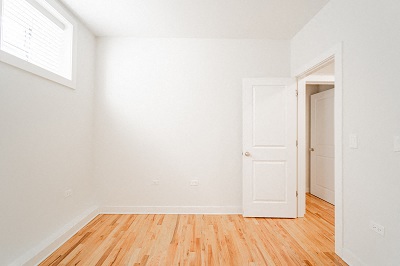 an empty room with white walls and a wooden floor