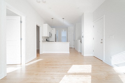 an empty kitchen and living room with white walls and wood floors