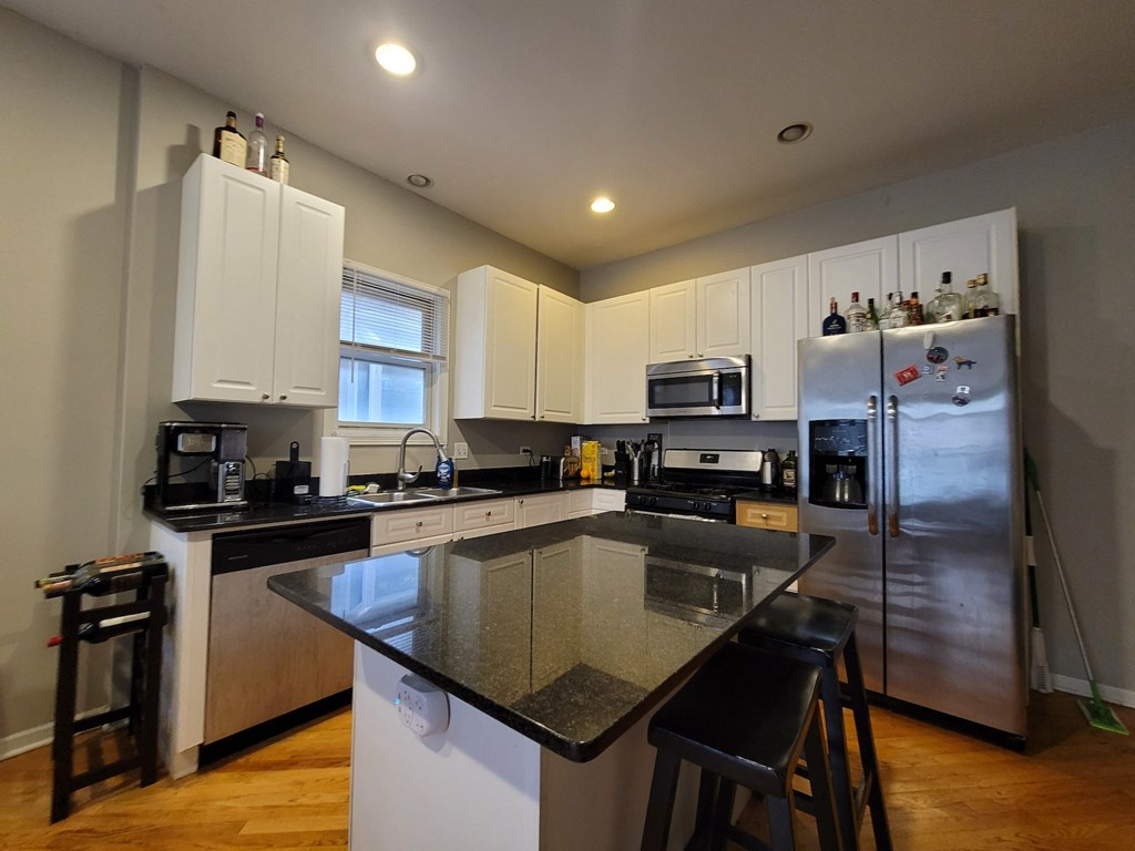 a kitchen with stainless steel appliances and a black counter top