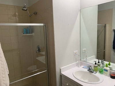 a bathroom with a sink and a shower and a mirror