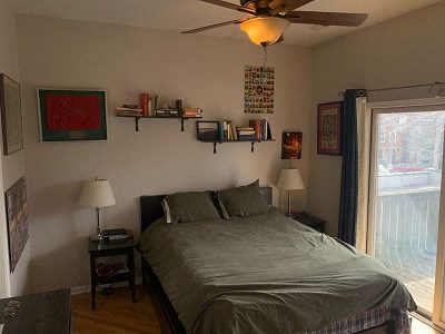 a bedroom with a bed and a ceiling fan