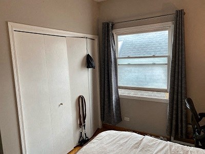 a bedroom with a bed and a window and a closet