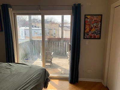 a bedroom with a sliding glass door to a balcony