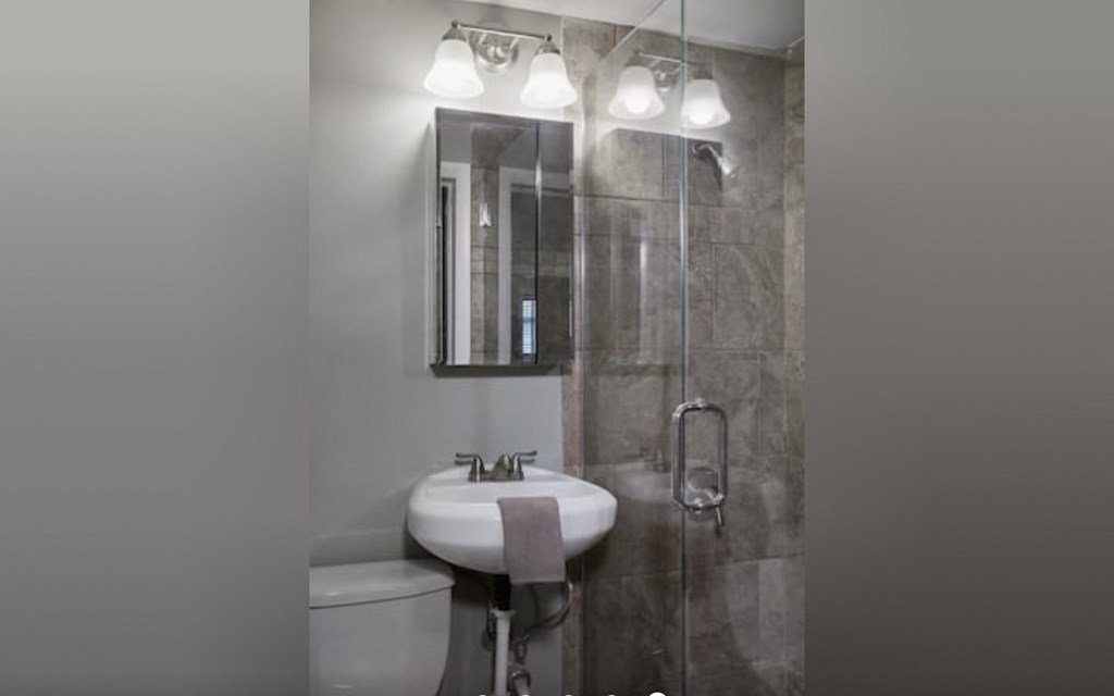 a bathroom with a sink and a shower and a mirror