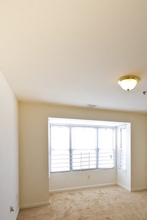 Bedroom with white walls and carpeted floors - Photo Gallery 6