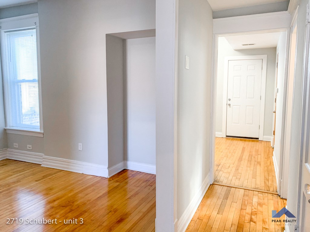 an empty room with wooden floors and a white door