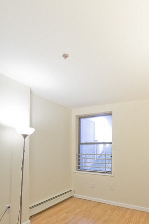 Bedroom with hardwood floors, window and wall lamp - Photo Gallery 6
