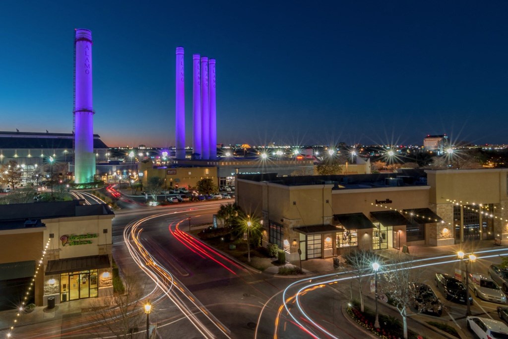 a city at night with purple towers in the background