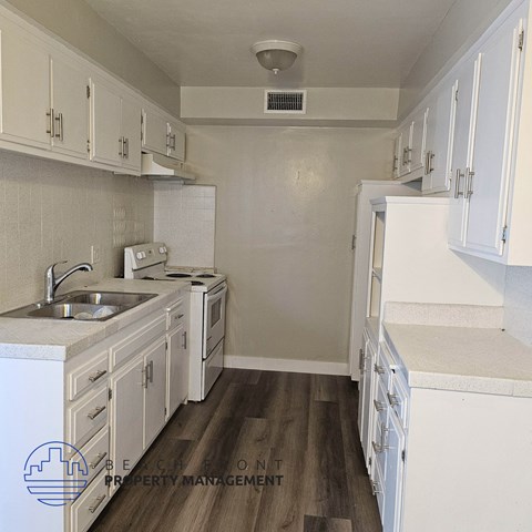 a small kitchen with white cabinets and a sink
