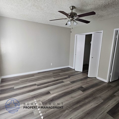 a living room with wood flooring and a ceiling fan
