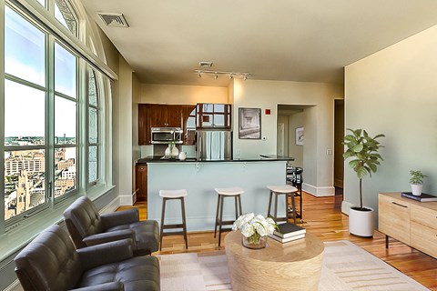 A living room with a bar area and a view of the city.