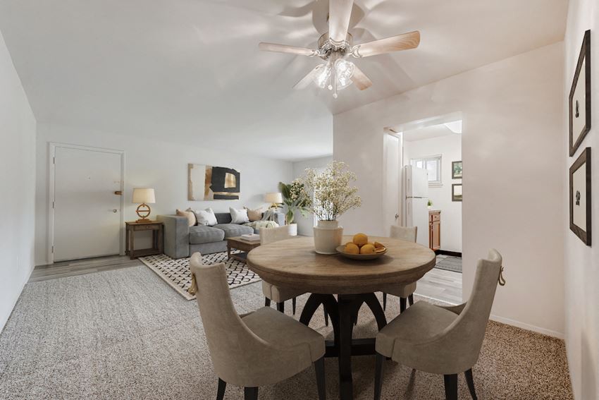 a living room with a dining room table and a ceiling fan