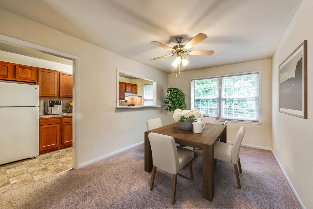 a dining room with a table and chairs and a ceiling fan
