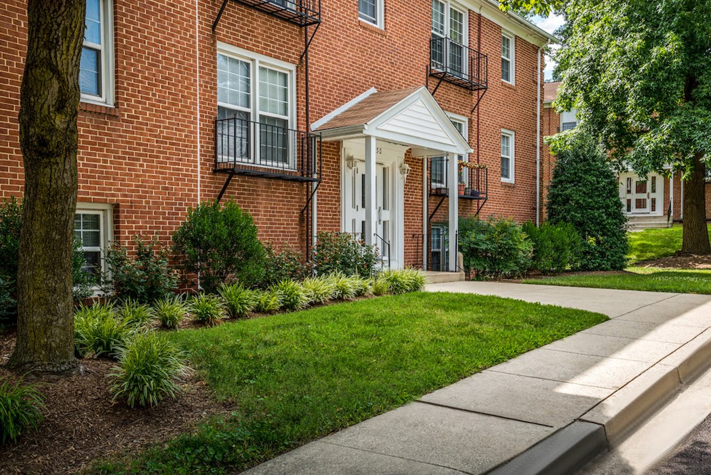 a sidewalk in front of a brick building