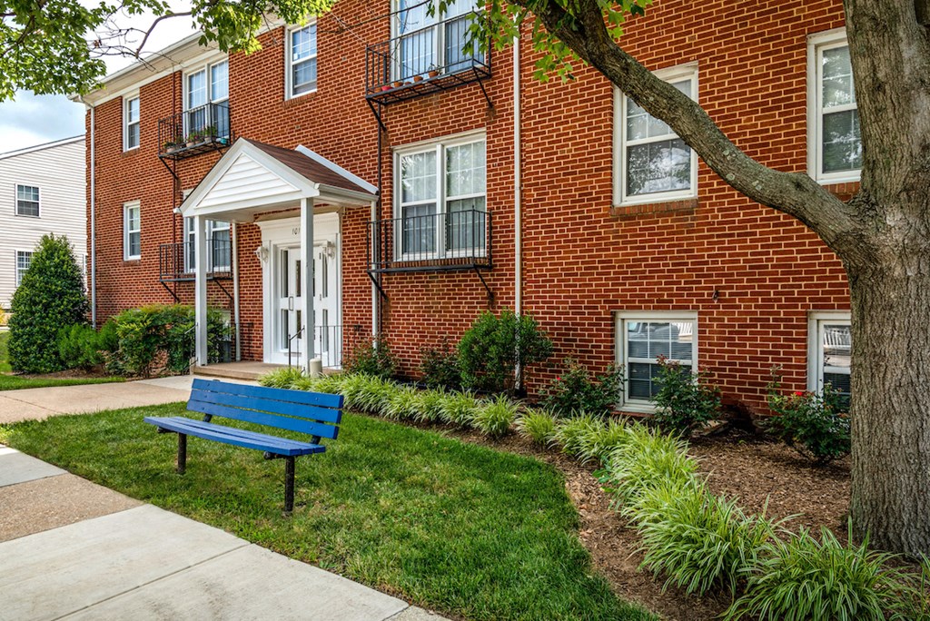 a blue bench in front of a brick building