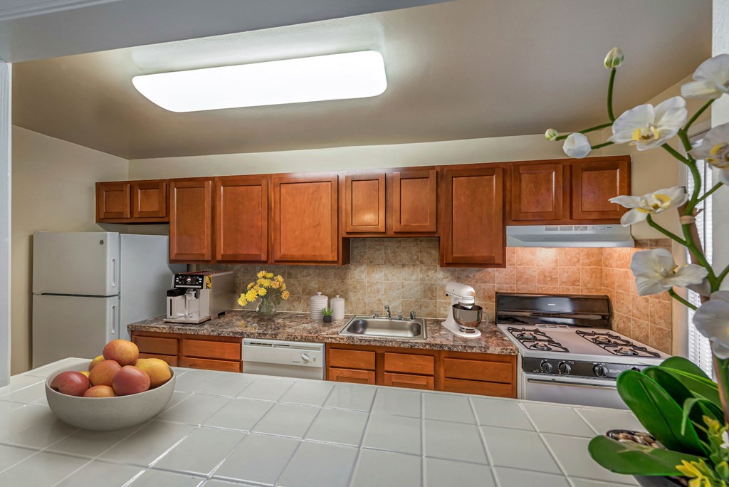 a kitchen with wooden cabinets and a bowl of fruit