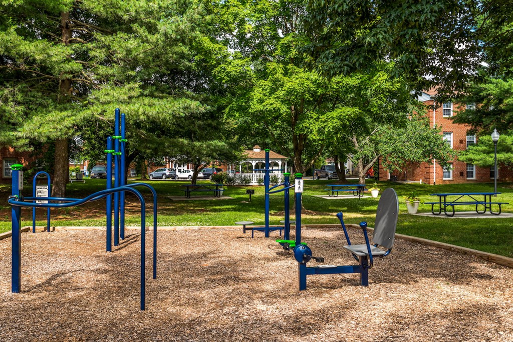 a playground with a chair and a bench in a park