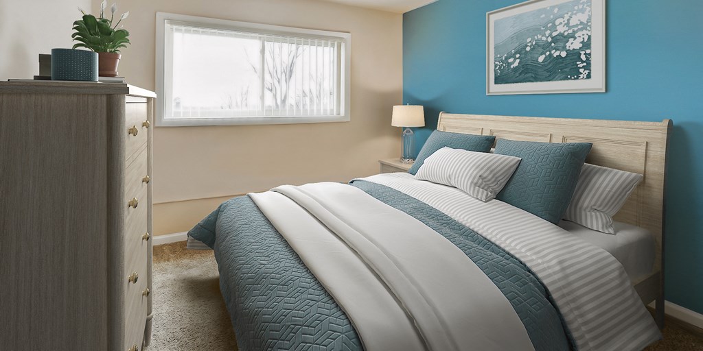 a blue and white bedroom with a bed and a window