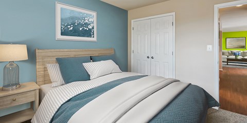 a bedroom with a bed and a door to a living room