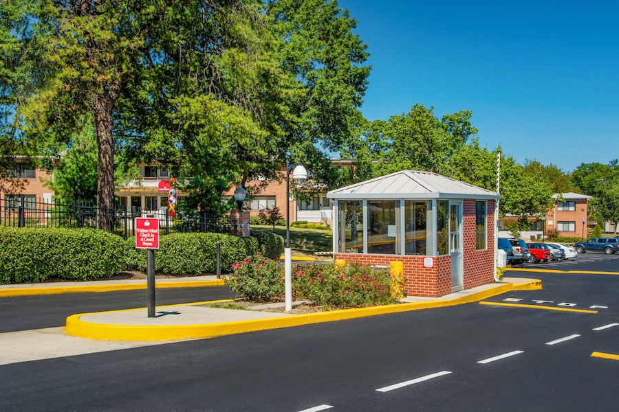 a gazebo at the corner of a street with a parking lot