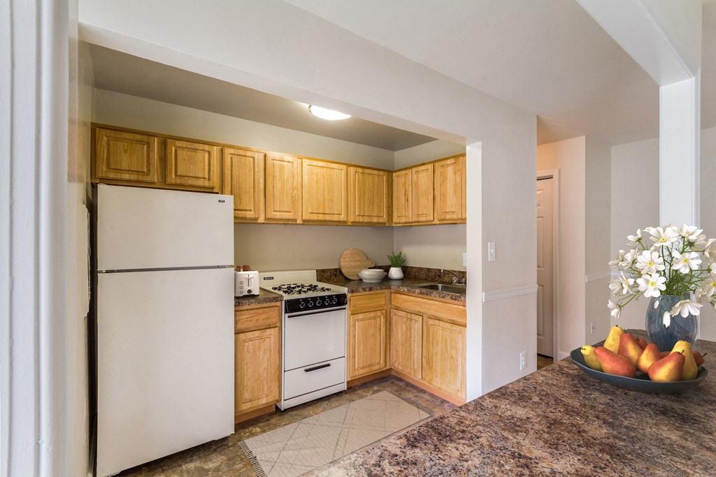 a kitchen with white appliances and wooden cabinets