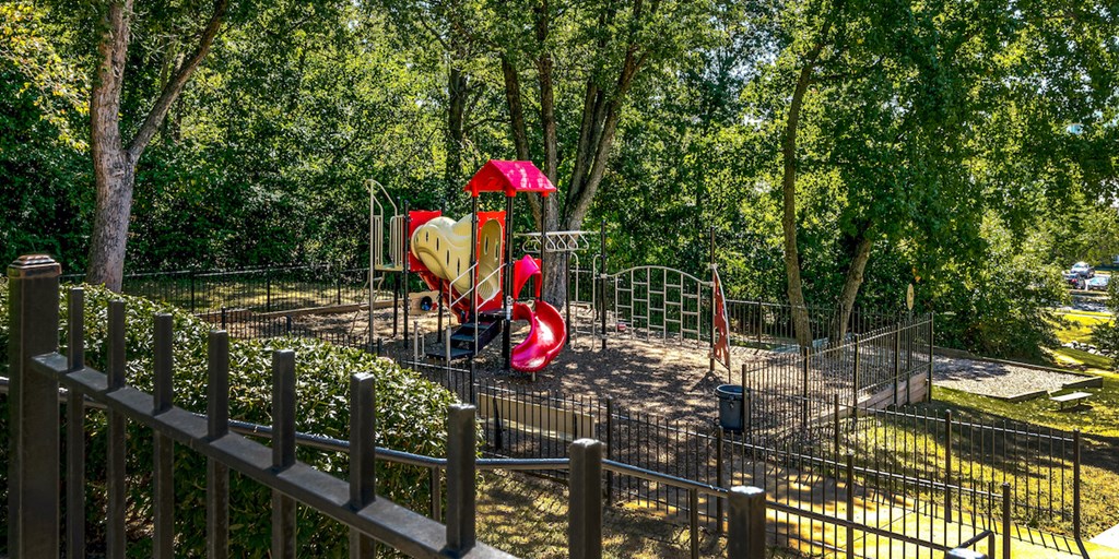 a playground with a red slide in a park
