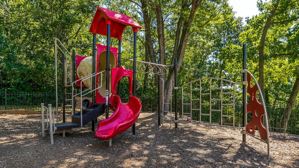 a playground with a red slide and other play equipment