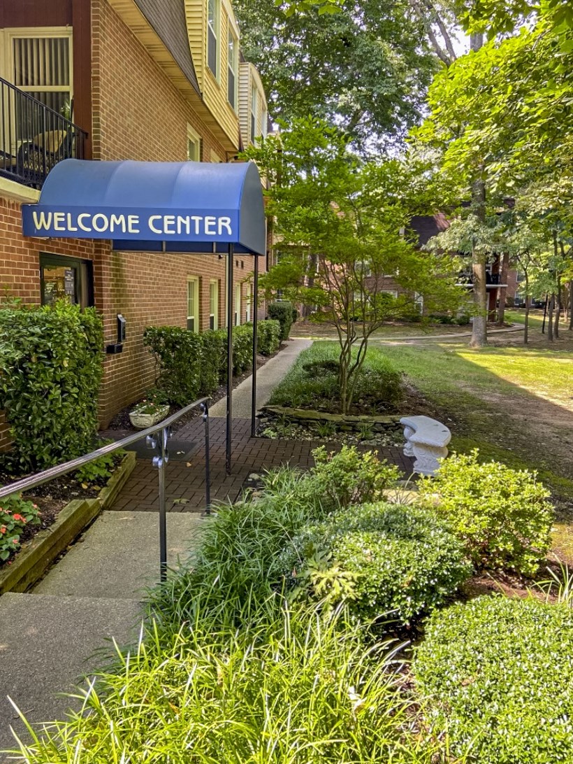 a blue welcome center sign in front of a building