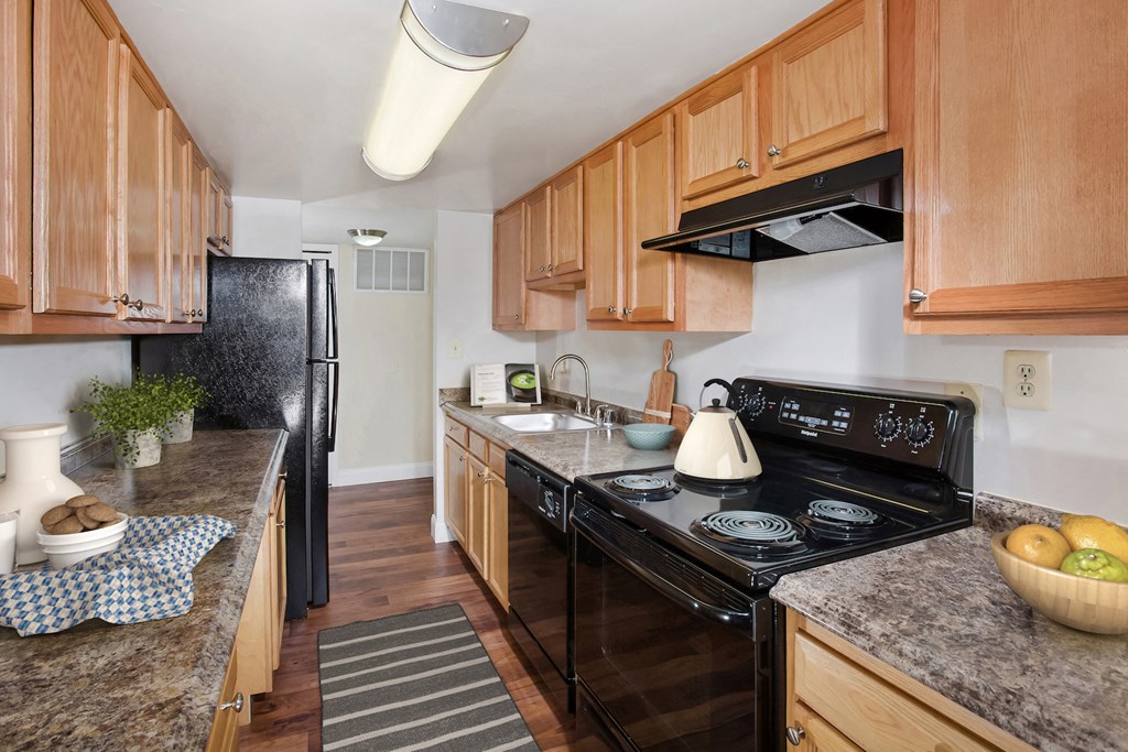 a kitchen with black appliances and wooden cabinets