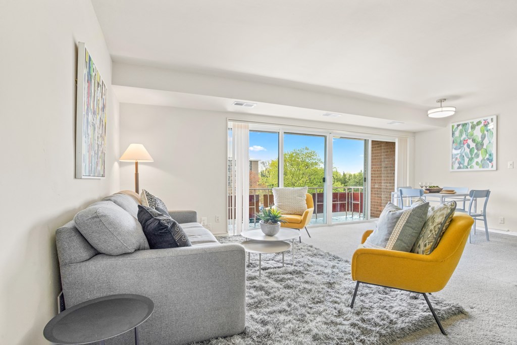 a living room with a couch and chairs and a sliding glass door