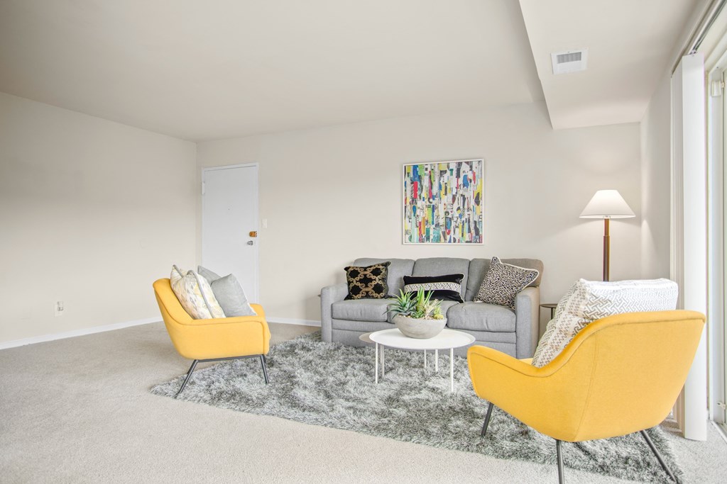 a living room with two yellow chairs and a couch