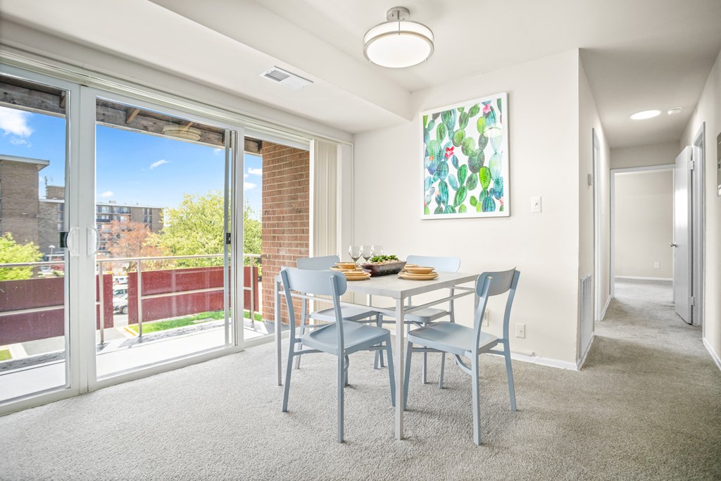 a dining room with a table and chairs and sliding glass doors