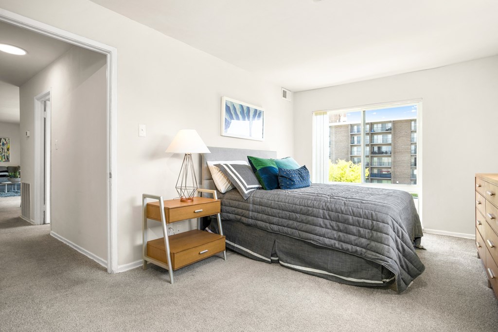 a bedroom with a bed and a dresser and a window