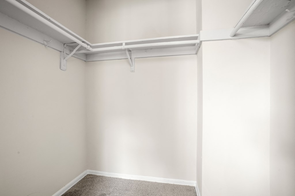an empty room with white walls and a white pipe on the ceiling