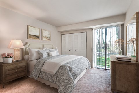 a bedroom with a bed and a door to a balcony