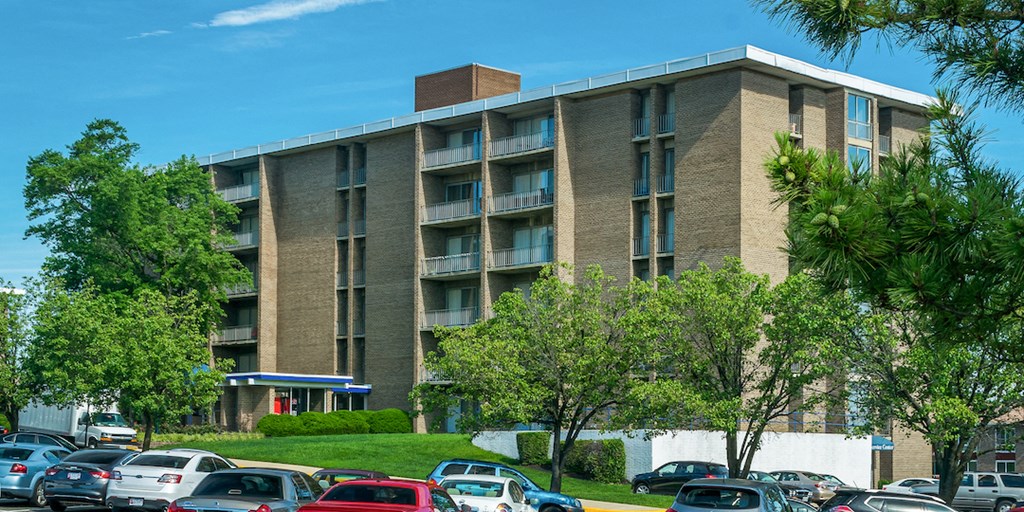 an apartment building with a parking lot full of cars