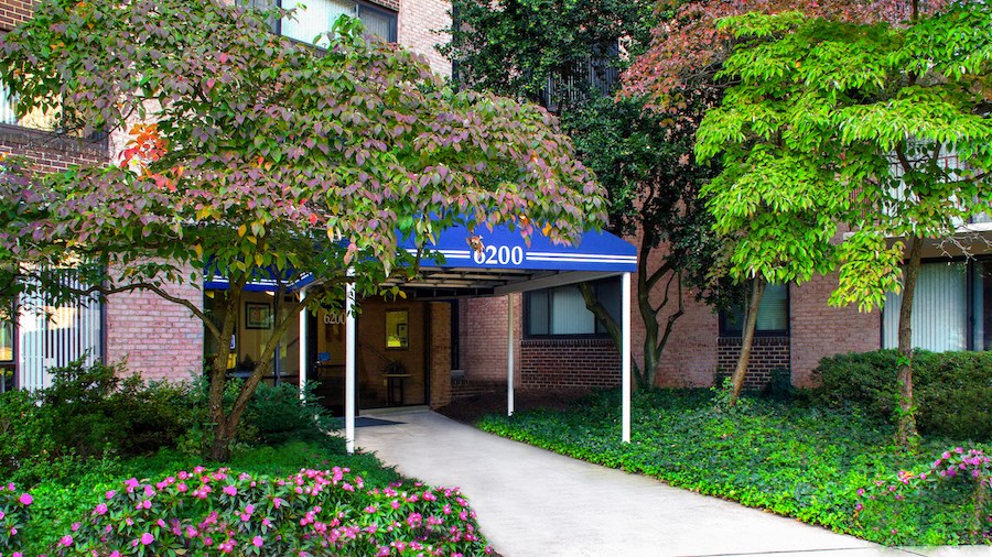 a brick building with a blue sign and a sidewalk