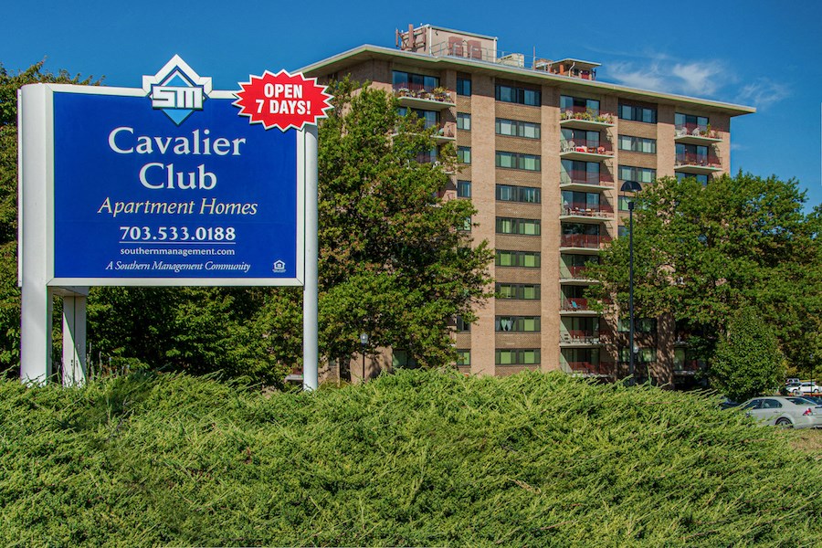 a sign for caviar club apartment homes in front of a building