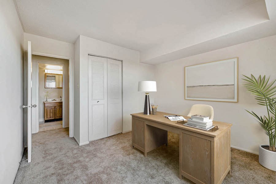 an office with a desk and a door to a bathroom