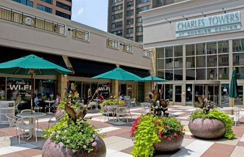 A patio area with tables and chairs and umbrellas.