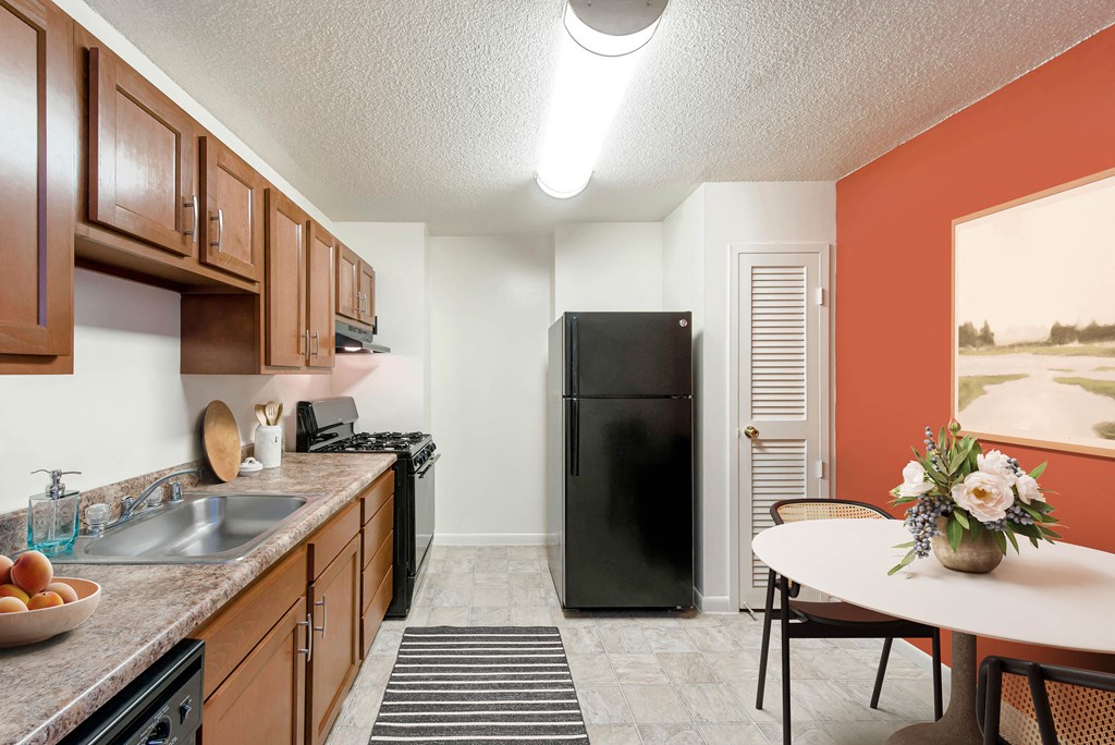 our apartments offer a kitchen with a black refrigerator and a table