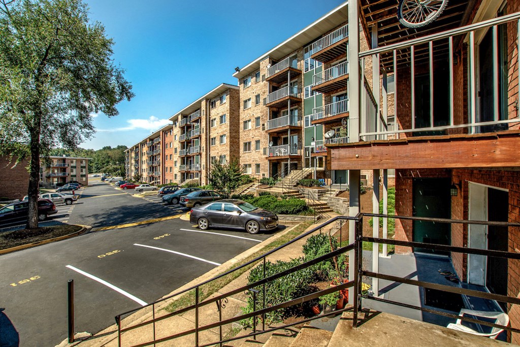 a view of a street with cars parked in front of an apartment building
