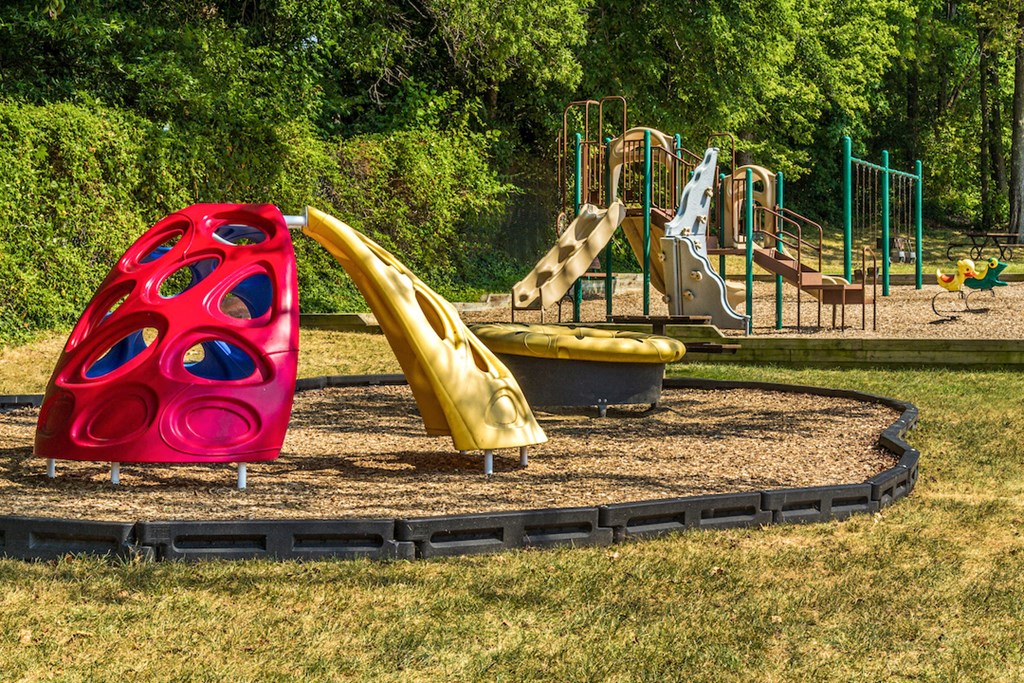 a playground with a red slide and a yellow slide