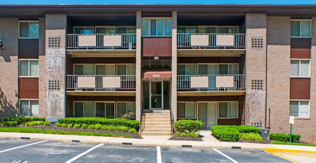 an apartment building with balconies and a parking lot