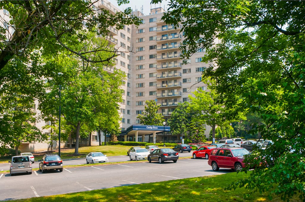 a busy city street with cars parked in front of a tall building