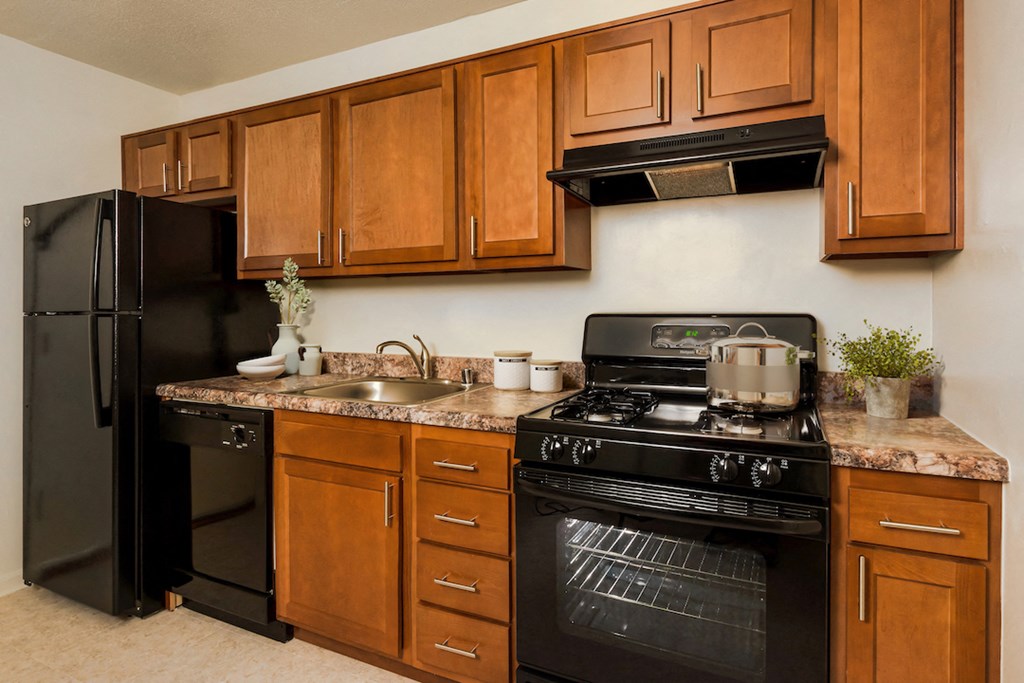 a kitchen with black appliances and wooden cabinets
