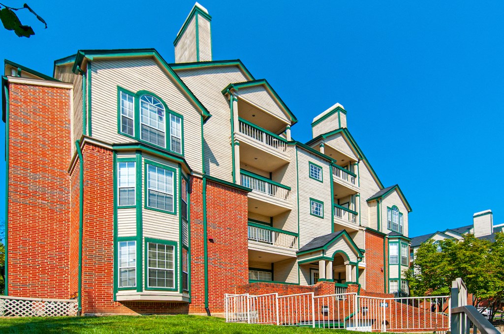 a large apartment building with red brick and green siding
