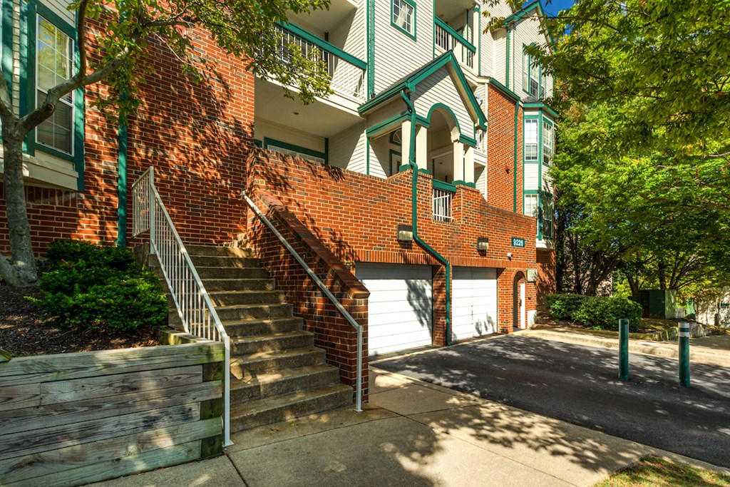 a brick apartment building with stairs and a sidewalk