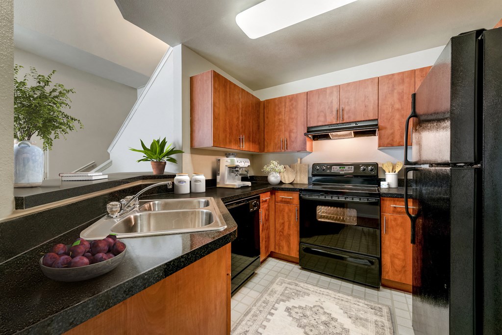 a kitchen with black appliances and wood cabinets