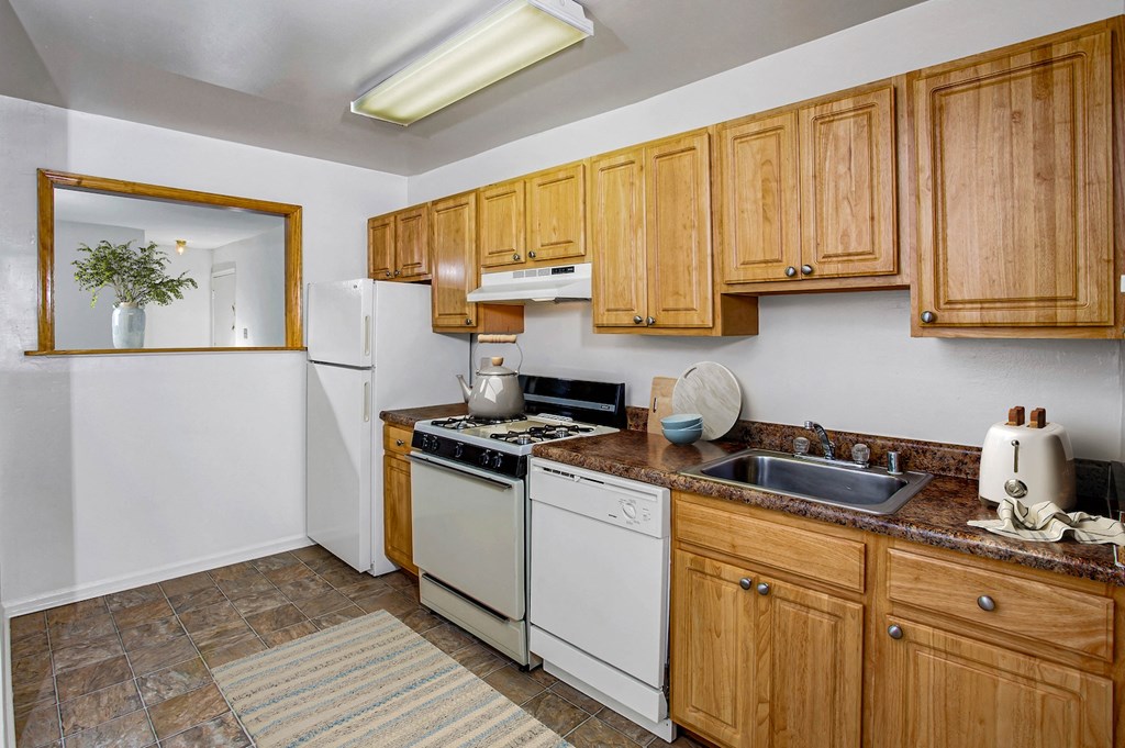 a kitchen with white appliances and wooden cabinets